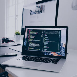 aptop displaying code on a modern workspace desk at a digital marketing agency office.